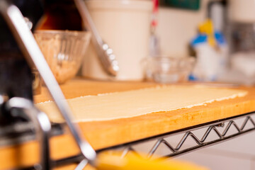Fototapeta na wymiar Making Pasta and Tortellini at Home on Wooden Rack and Chrome Pasta Maker