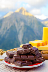 Handmade pure dark swiss chocolate and Alpine mountains on background