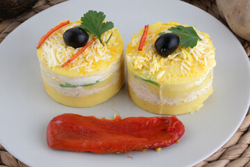 peruvian typical food called causa with mashed potatoes ans avocado