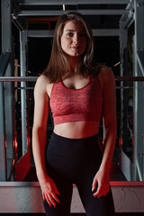 Beautiful young fitness woman doing squats with a barbell on the Smith Machine in the gym. Beautiful woman poses for the camera.