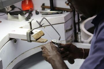 hands of a jeweler with a tool in a workshop