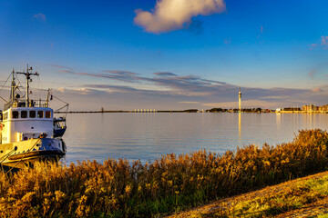 Old tug in a  modern harbor at sunset