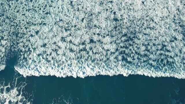Beautiful background screen saver video of surfing wave roll over quiet waters. Surf with white foam swirls washing over ocean or sea shore. High or low tide, surfers waiting for perfect wave