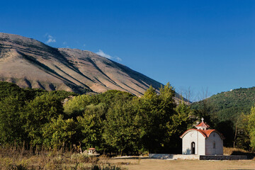 Albanian panorama of  countryside with a  small white Orthodox church with red roof, near the blue eye, main tourist attraction of Albania, Europe.