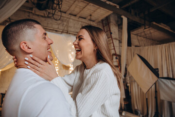 The guy and the girl celebrate the New Year. A loving couple have fun on Christmas in a cozy studio setting. New Year's love story.