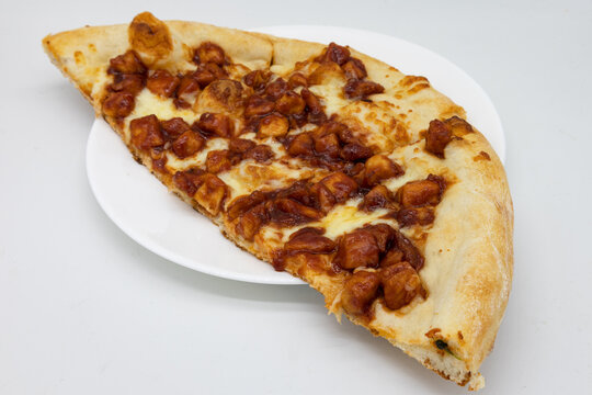 Half Of A New York Style Barbecue Chicken Pizza On A White Plate