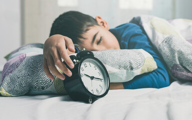 
Boy fast asleep in bed with an alarm clock in his hands
Conceptual of relaxation, tranquility,...