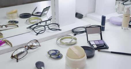 Cosmetic set on light dressing table. many of makeup products and eyeglasses on vanity desk. accessories and earrings on white place in backstage where models getting ready for fashion show. - Powered by Adobe