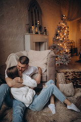Obraz premium The guy and the girl celebrate the New Year. A loving couple have fun on Christmas in a cozy studio setting. New Year's love story.