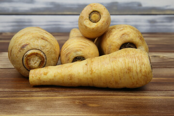 Close up of group raw isolated parsnip root vegetables with wooden background