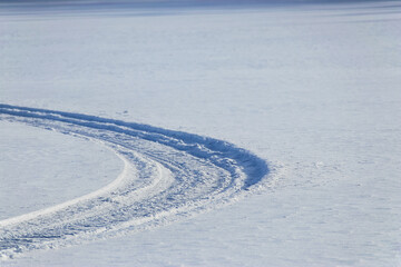 Fototapeta na wymiar snowmobile tracks on a frozen lake in finland