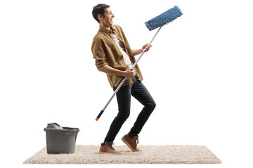 Happy man dancing and making air guitar with a cleaning mop