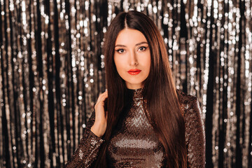 a girl in a shiny jacket on a silver background of New Year's rain