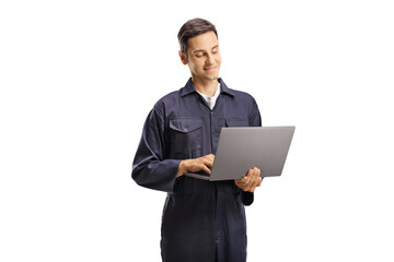 Young male worker in an overall uniform with a laptop computer