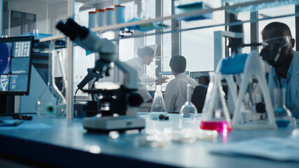 Fototapeta premium Medical Science Laboratory with Diverse Multi-Ethnic Team of Biotechnology Scientists Developing Drugs, Microbiologist Working on Computer with Display Showing Gene Editing Interface.