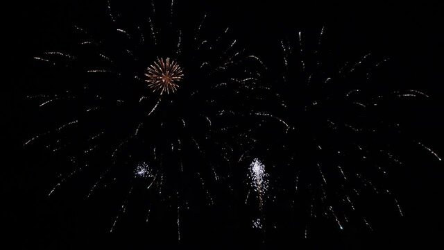 Slowmotion gimbal tilting shot of a beautiful of a firework show at night.