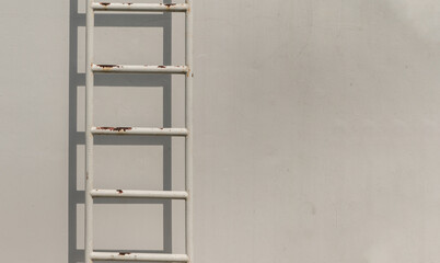 White metal fire escape attached to a wall and leading to the roof of a building. Copy space, No focus, specifically