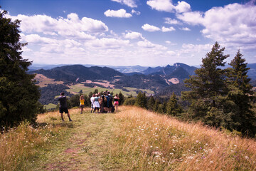 Bielsko Biala, South Poland - July 29, 2017: Group of young people trekking hiking in Polish mountains during summer against dramatic clouds