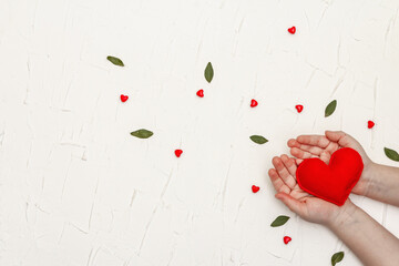 Children's hands are holding a homemade felt heart