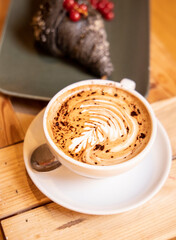 cappuccino closeup with charcoal brioche with currant on background