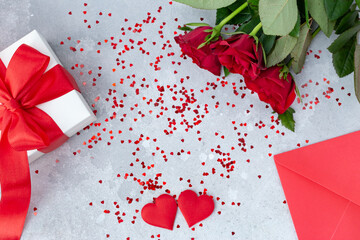 St. Valentines day festive background . red roses, red envelope , white gift box with red ribbon and two red hearts  copy space. flatly, mockup for card, 