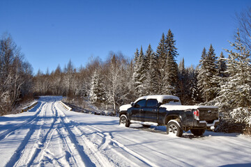 Pickup on the edge of a snowy road in Canadian forest in Quebec - obrazy, fototapety, plakaty