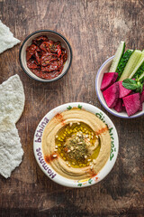 Pumpkin hummus with fresh vegetables on a dark wooden background, copy space