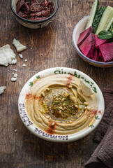 Pumpkin hummus with fresh vegetables on a dark wooden background