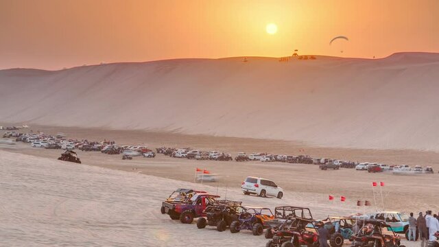 Buggies in sand desert at the sunset timelapse. People and jeep cars on weekend. Qatar