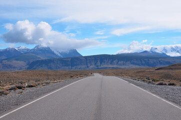 Straße durch Patagonien mit Blick auf Berge und blauem Himmel.