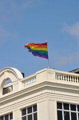 Rainbow flag on the white building in UK after Pride parade with blue sky in the background