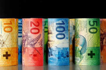 Several rolled-up Swiss banknotes