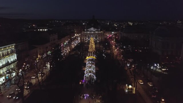 Arial view of Christmas tree in city Lviv, Ukraine square oposite Opera House, December 2020. New year 2021 with colored lights in Fair market. Old town at night. Santa Claus celebration holidays