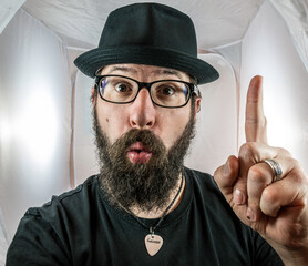 A bearded man with hat and glasses has an idea