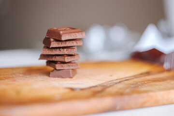 Pieces of chocolate on the wooden surface