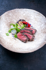 Modern style barbecue dry aged angus beef fillet steak natural with vegetable and lettuce served as...