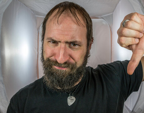 A bearded man showing disrespect and humbs down