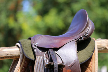 Old leather saddle with stirrups for show jumping race