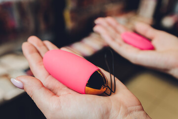 Anal plug with a fluffy pink tail with female hands. Toy for adult games.