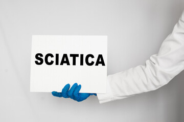 The doctor's blue - gloved hands show the word SCIATICA - . a gloved hand on a white background. Medical concept. the medicine