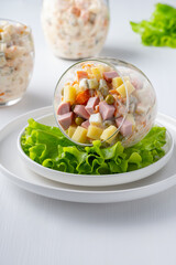 Traditional Russian salad Olivier with vegetables, ham and mayonnaise.