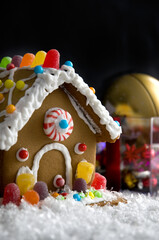 Naklejka premium Colorful Gingerbread House with Candies and White Snow