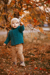 Joyful child runs. A boy dressed in a green jacket and brown pants.