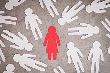 Red paper figure of a woman against white silhouettes of men. Symbol of sexism.