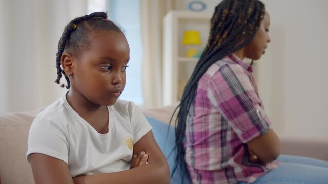 Young african mother and small daughter avoid talking after misunderstanding