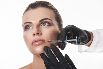 Lips Augmentation Concept. An attractive woman getting injection on lips.