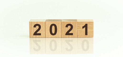 2021-2020 written on a wooden cube, white background