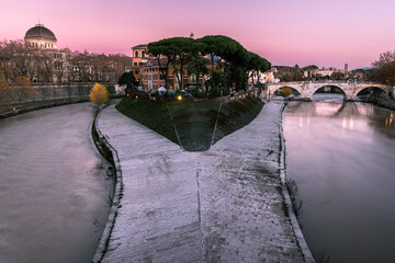 il tramonto sull'isola tiberina ed il fiume tevere, con stormi di uccelli nel cielo
