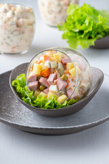 Traditional Russian salad Olivier with vegetables, ham and mayonnaise.