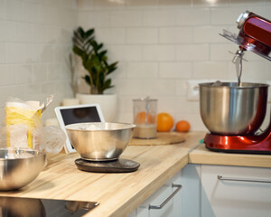 Cooking and baking food kitchen background at home, apartment, flour, scales, bowls, digital tablet with recipes on table